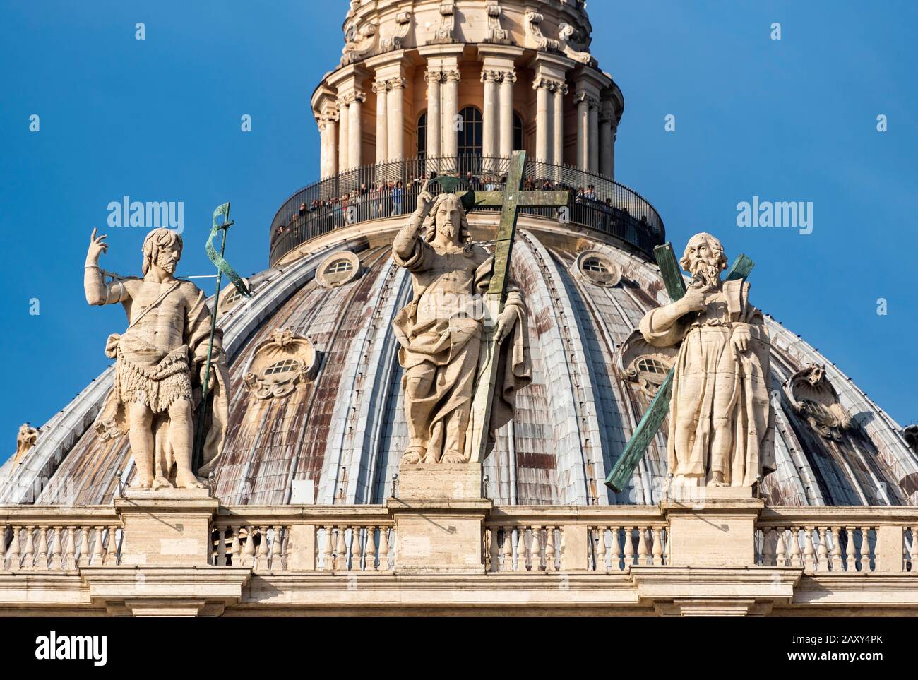 Statues of saints John the Baptist, Jesus Christ and St Andrew and cupola of St. Peter's basilica, Vatican, Rome, Italy Stock Photo