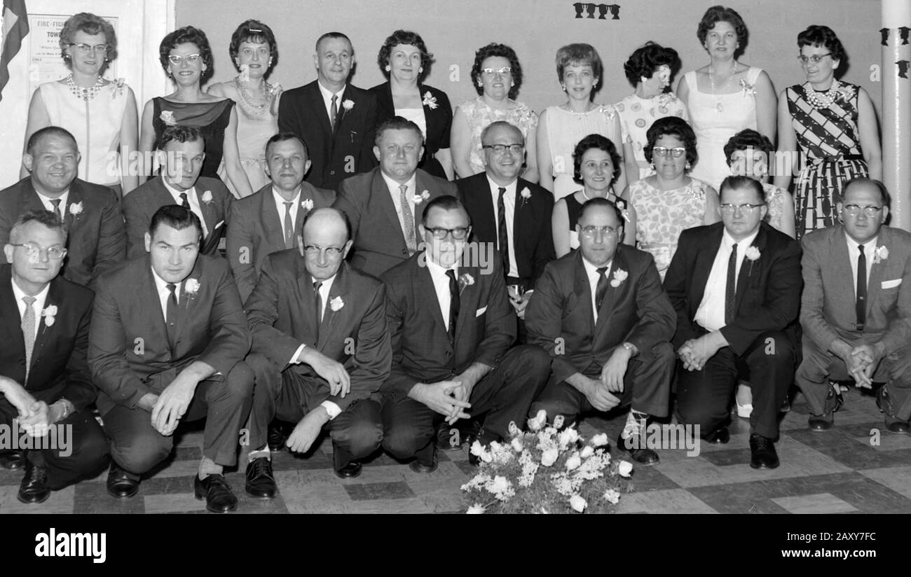 Group of middle-aged adults pose together at a gathering, ca. 1960. Stock Photo