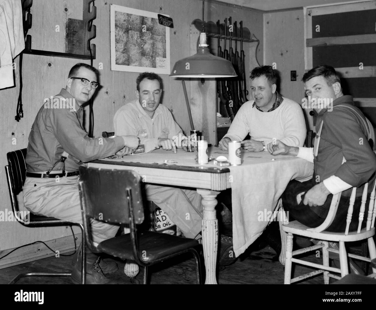 A group of men play cards in their hunting cabin in Wisconsin, ca. 1960. Stock Photo