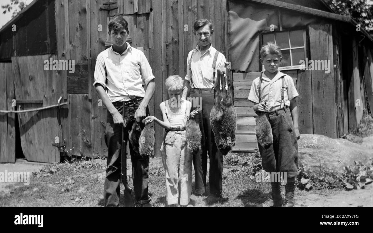 Father and sons display their hunting results, ca. 1930. Stock Photo