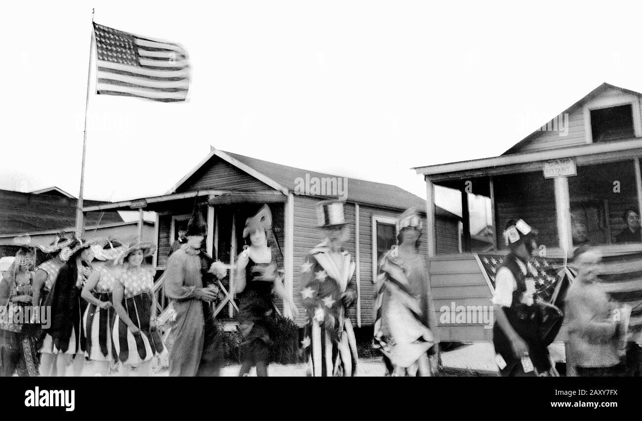 Resort Fourth of July parade marches past beach cabins in New England, ca. 1925. Stock Photo