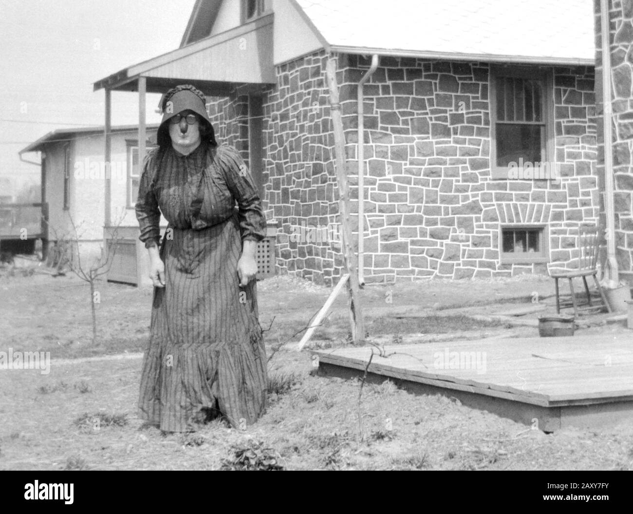 Bizarre woman stands in her backyard, ca. 1930. Stock Photo
