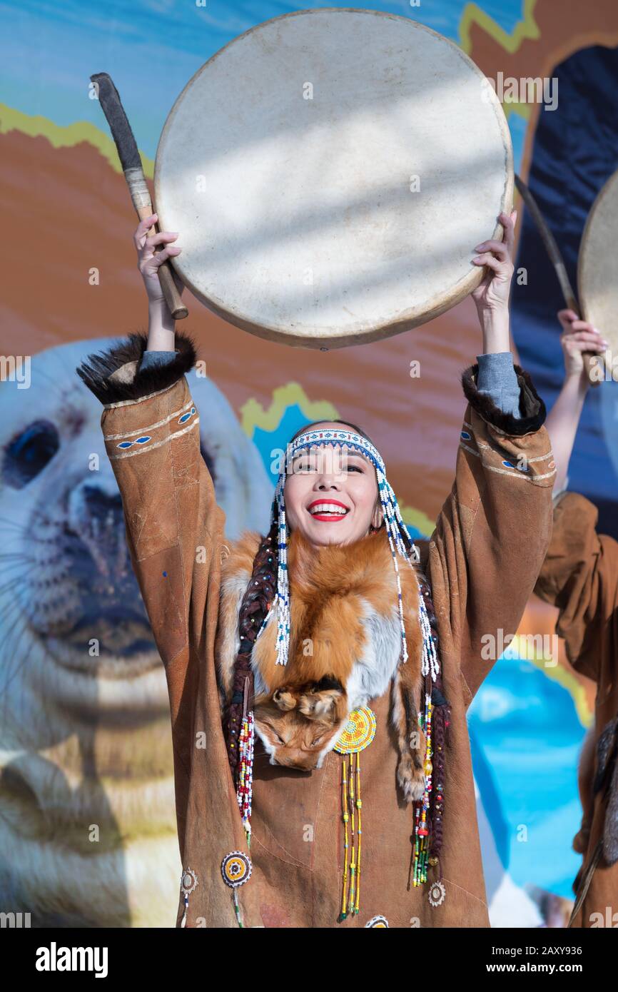 Female dancing with tambourine in national clothing indigenous inhabitants Kamchatka. Concert, celebration Koryak national holiday Hololo Day of Seal Stock Photo