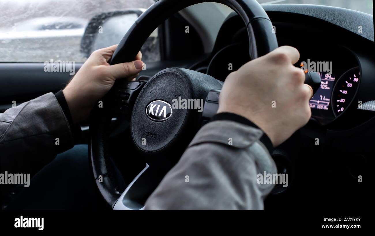Moscow, Russia - January 2, 2020: Black steering wheel of a car with the KIA logo close-up. Hands of the driver behind the wheel of a South Korean SUV Stock Photo
