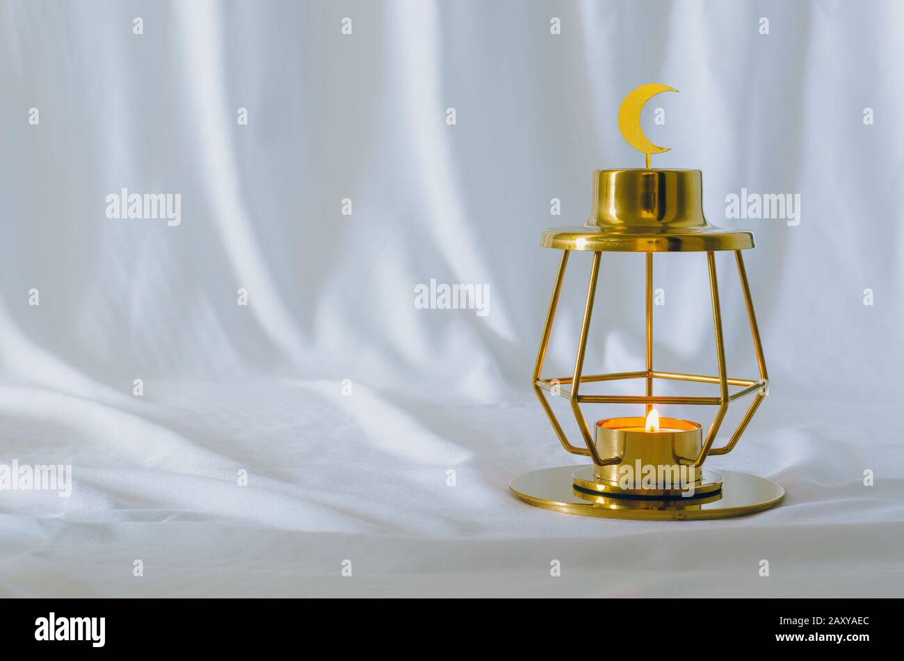 Modern golden lantern that have moon symbol on top with white background for the Muslim feast of the holy month of Ramadan Kareem. Stock Photo