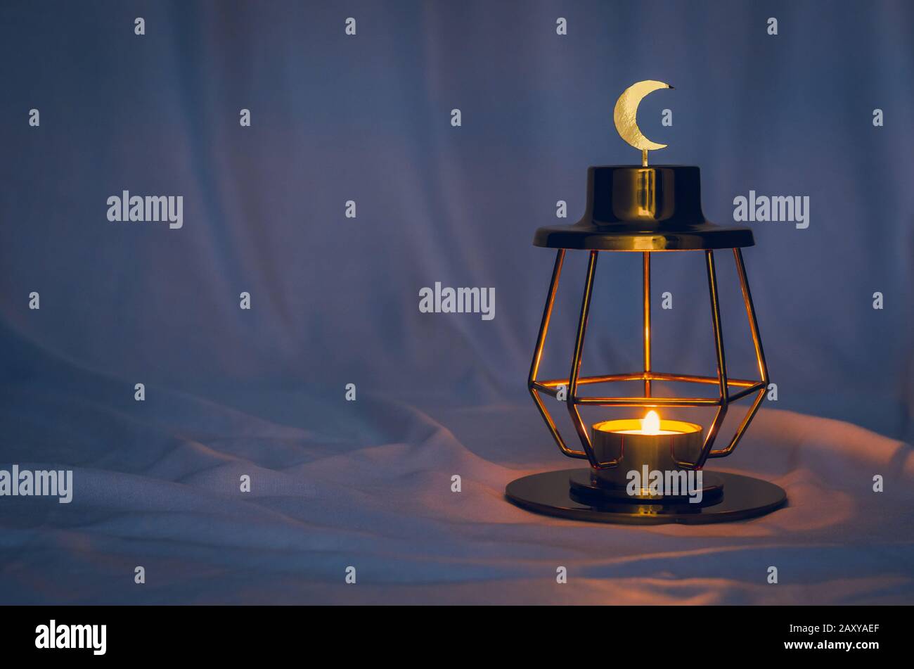 Modern golden lantern that have moon symbol on top with dark background for the Muslim feast of the holy month of Ramadan Kareem. Stock Photo