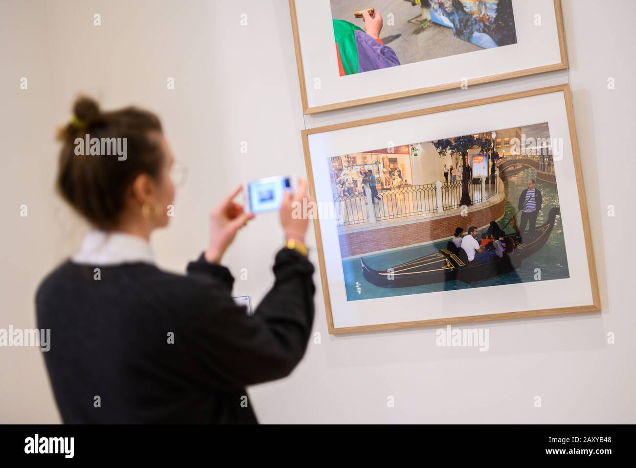 Emden, Germany. 07th Feb, 2020. A woman takes a picture of the artist Martin Parr's 'Small World' at the Kunsthalle Emden with her mobile phone. (to dpa 'Exhibition on places of longing focuses on the selfie factor') Credit: Mohssen Assanimoghaddam/dpa/Alamy Live News Stock Photo