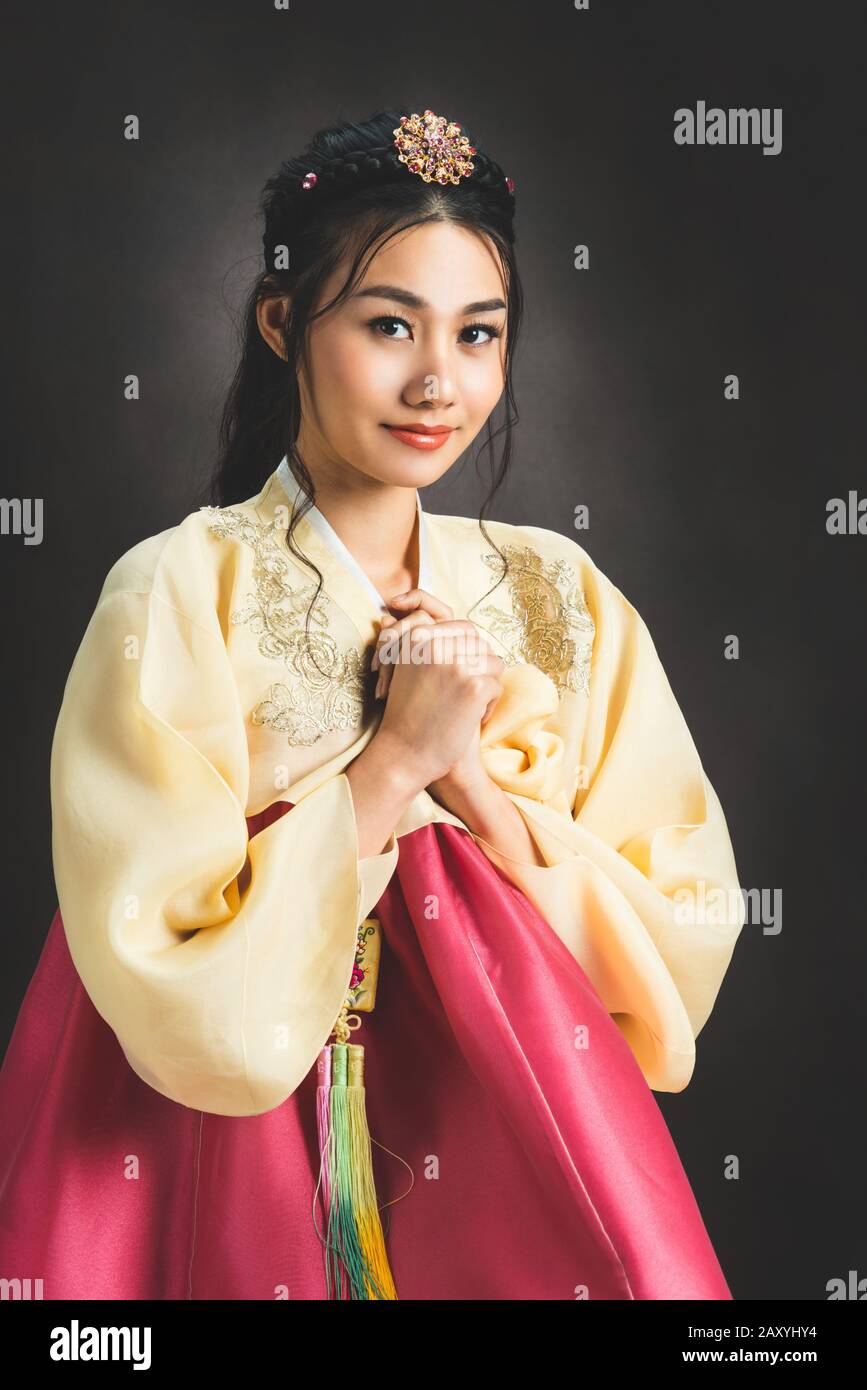 Korean woman wearing traditional korean dress (Hanbok) on black background in studio. Beautiful