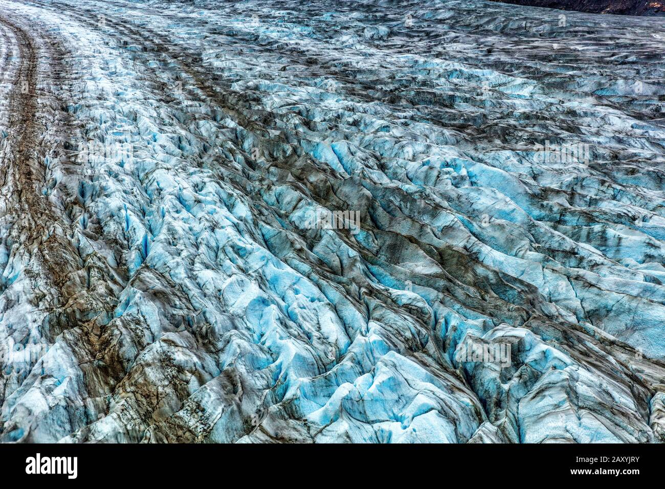 Glacier arm blue ice texture from above. Top aerial view from helicopter ride in Glacier Bay National Park, Alaska, USA. Shore excursion from cruise ship travel vacation. Stock Photo