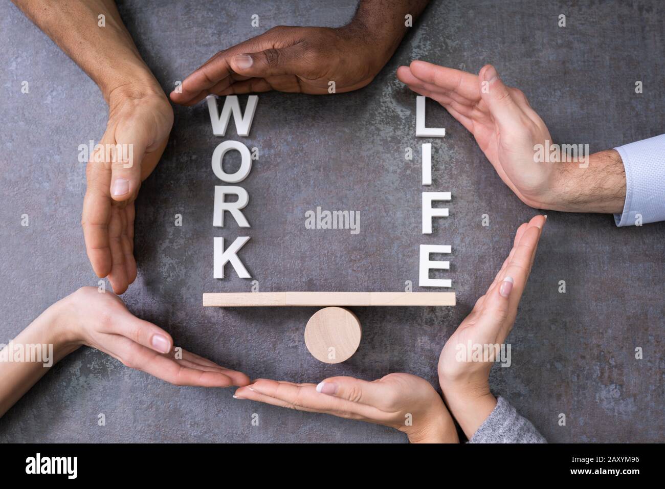 People Hands Protecting Balance Between Life And Work On Wooden Seesaw Stock Photo