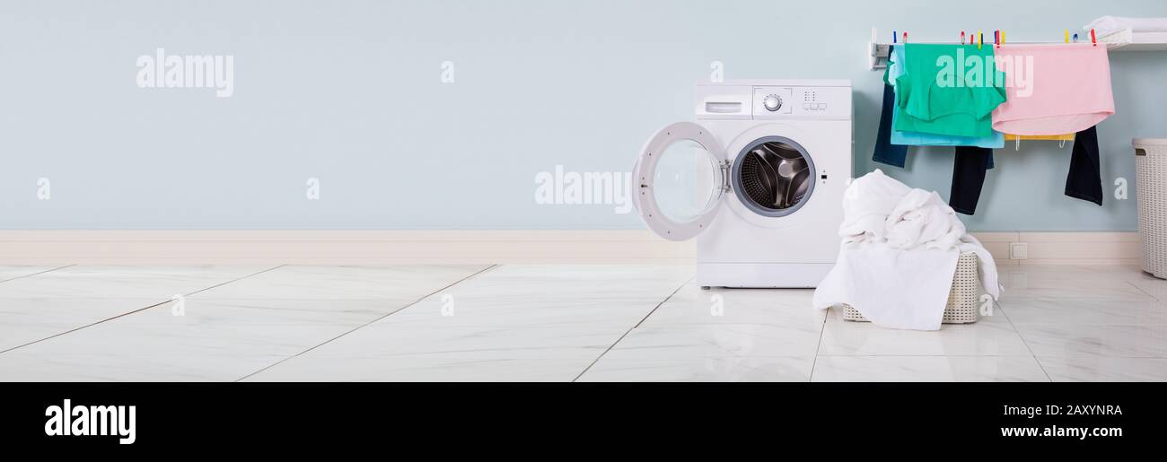 Empty Washing Machine With Pile Of Dirty Cloth In The Basket At Laundry