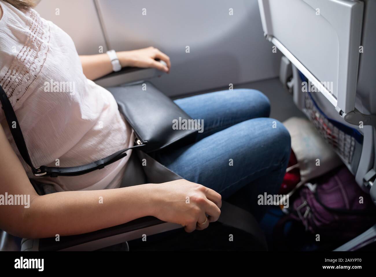 Nervous Woman Holding Armrests Tight In Airplane Stock Photo