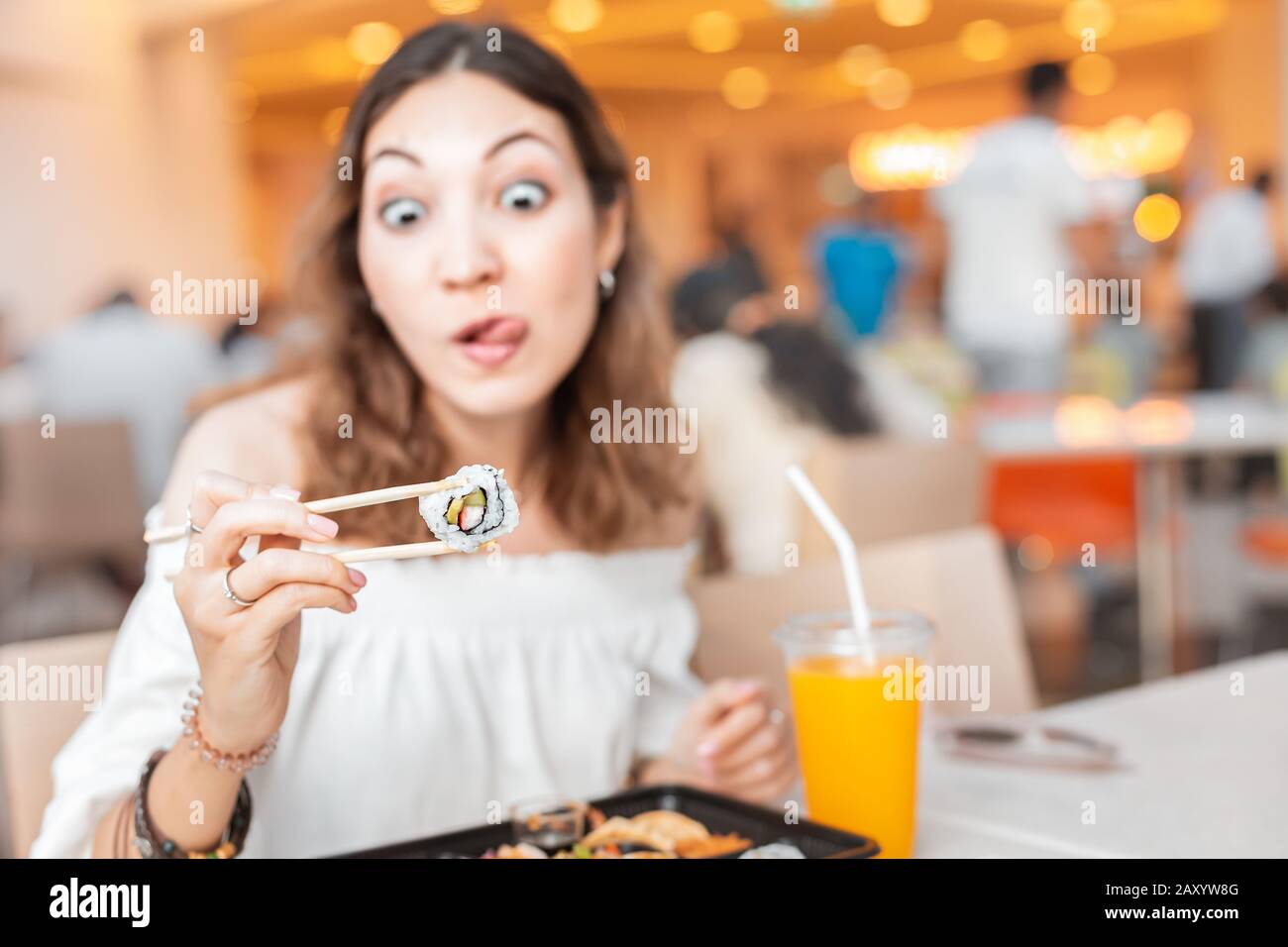 Funny Girl eating sushi with chopsticks while having Bento lunch in the
