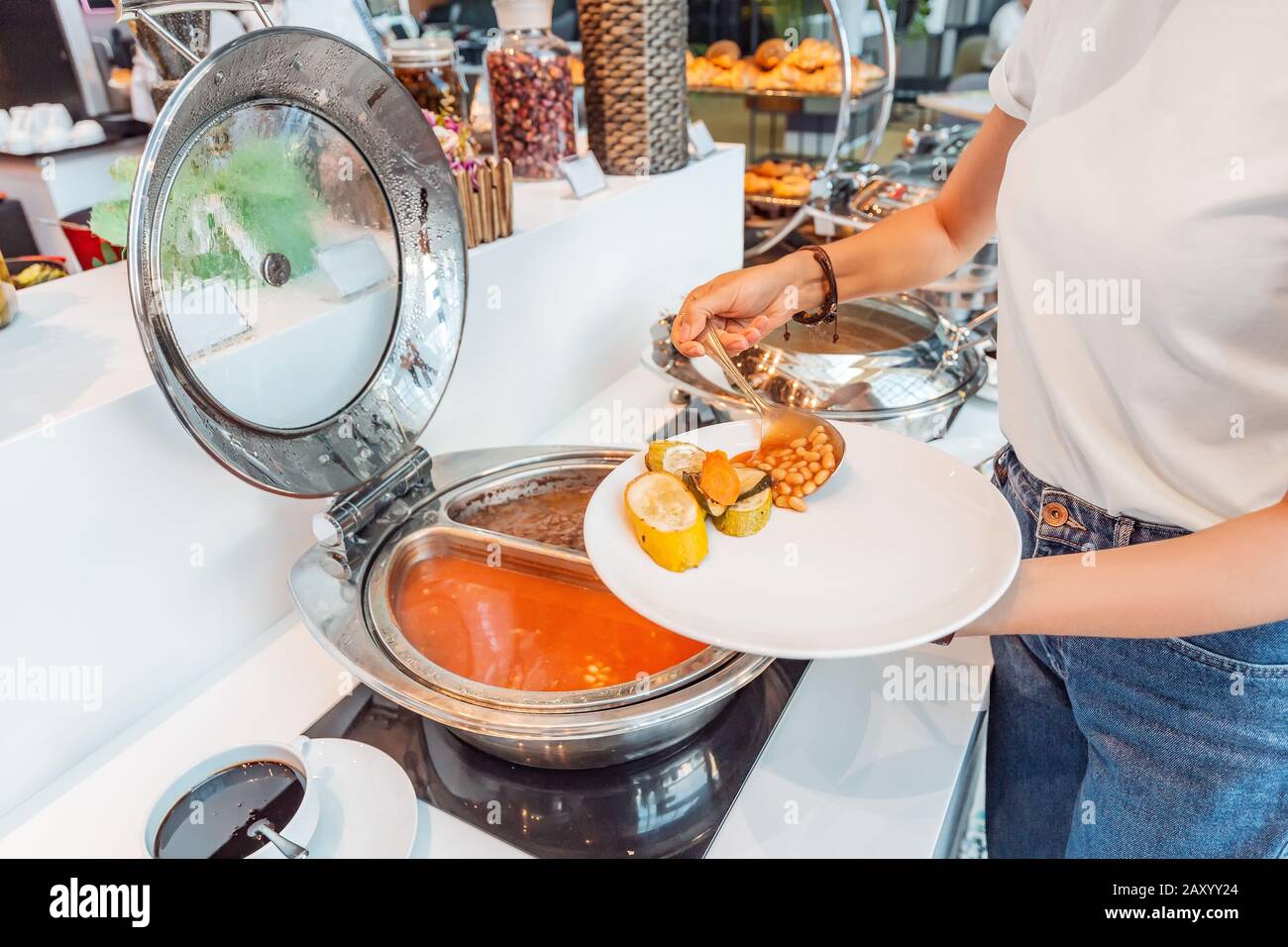 Woman choosing food in open buffet at breakfast in hotel Stock Photo