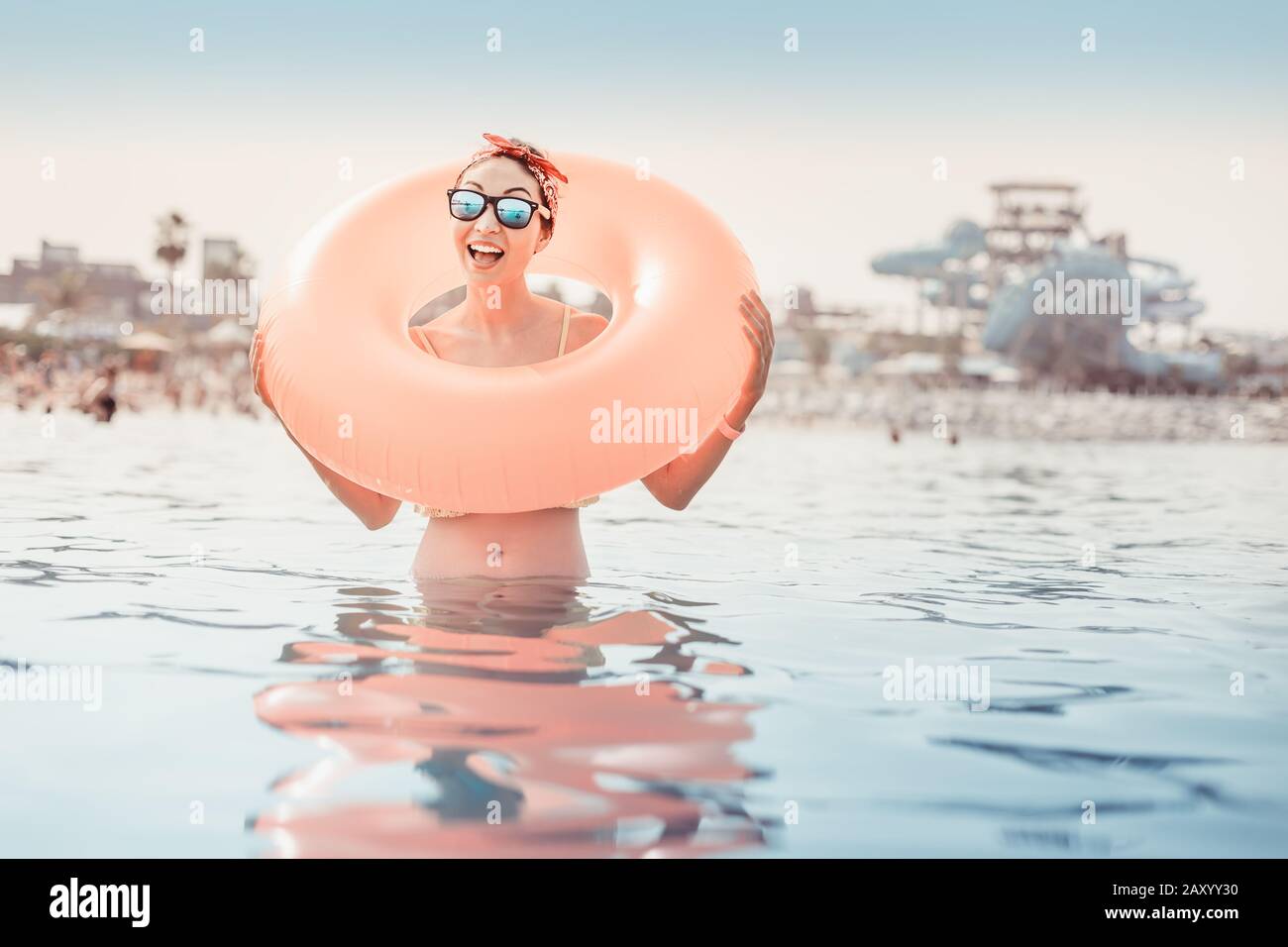 Happy Asian girl with an inflatable circle is resting and swimming at a popular seaside resort. Vacation and water aquapark concept Stock Photo