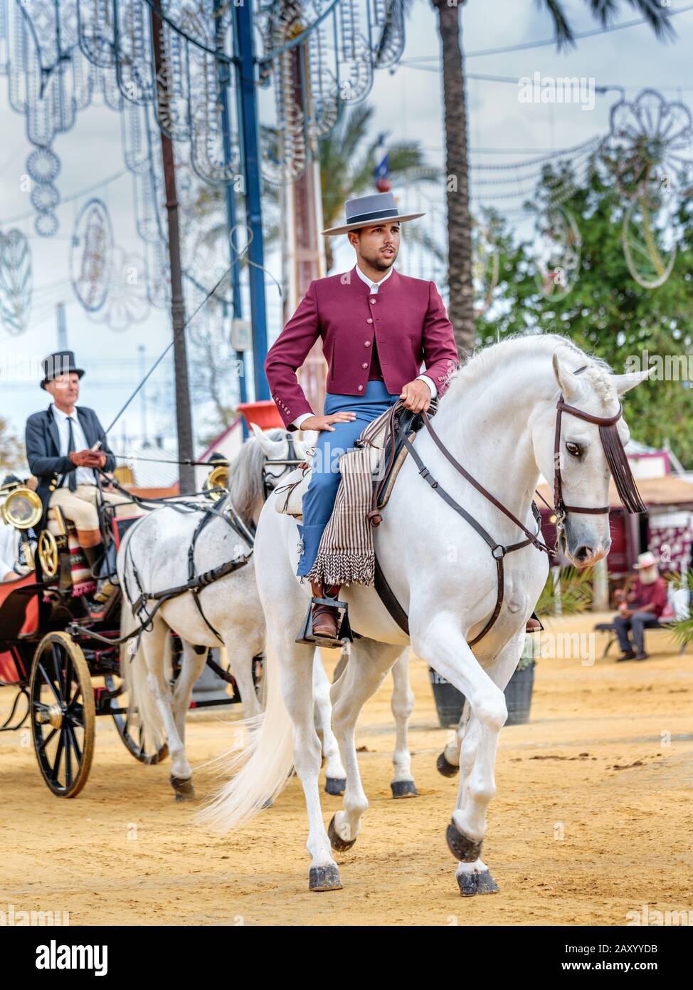 Riders and carriages in traditional festive dress, Jerez Horse Fair (Feria de Caballo) , Jerez de la Frontera, Cádiz Province, Andalusia, Spain Stock Photo