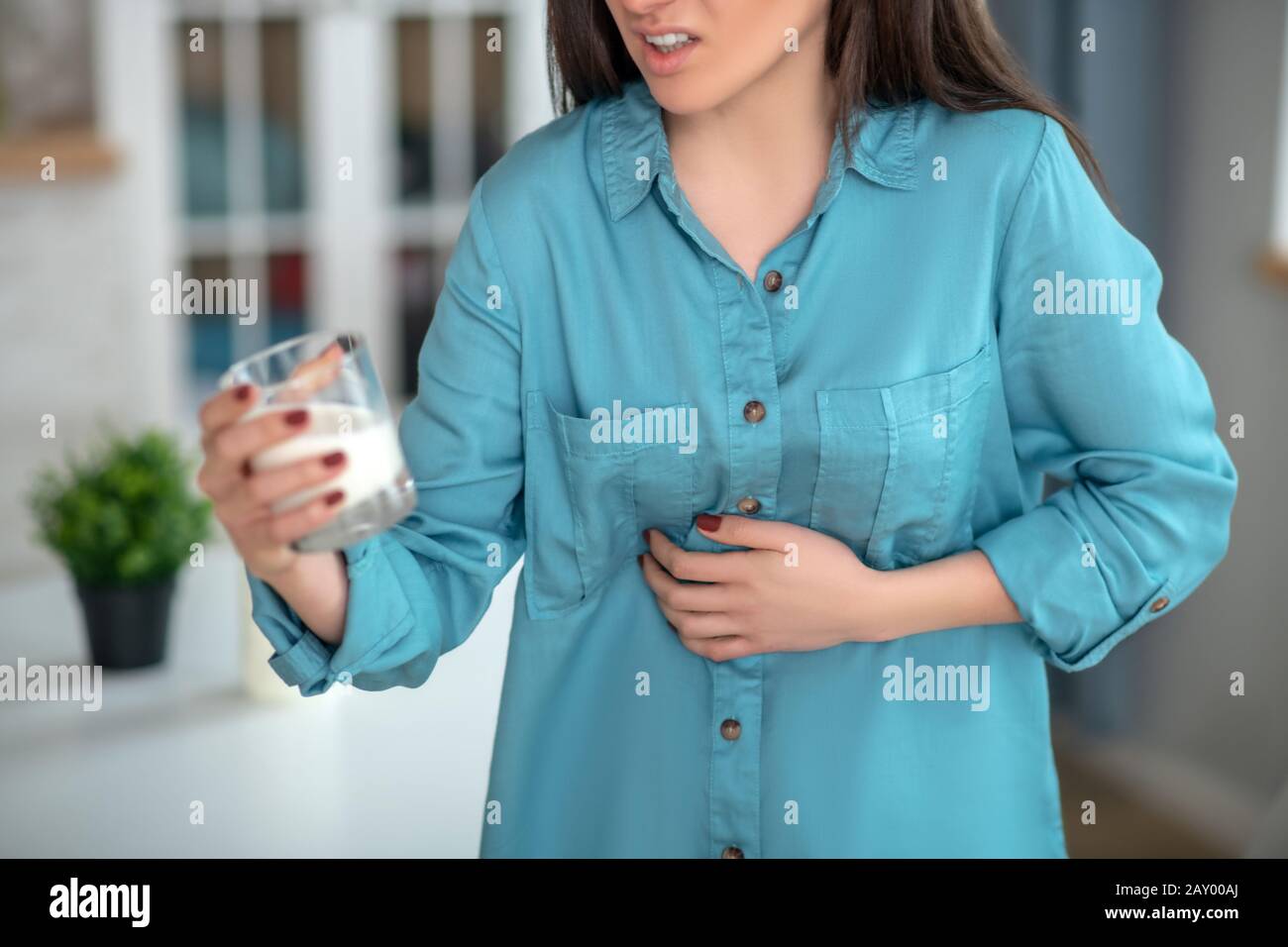 Woman having a stomach ache and drinking milk Stock Photo Alamy