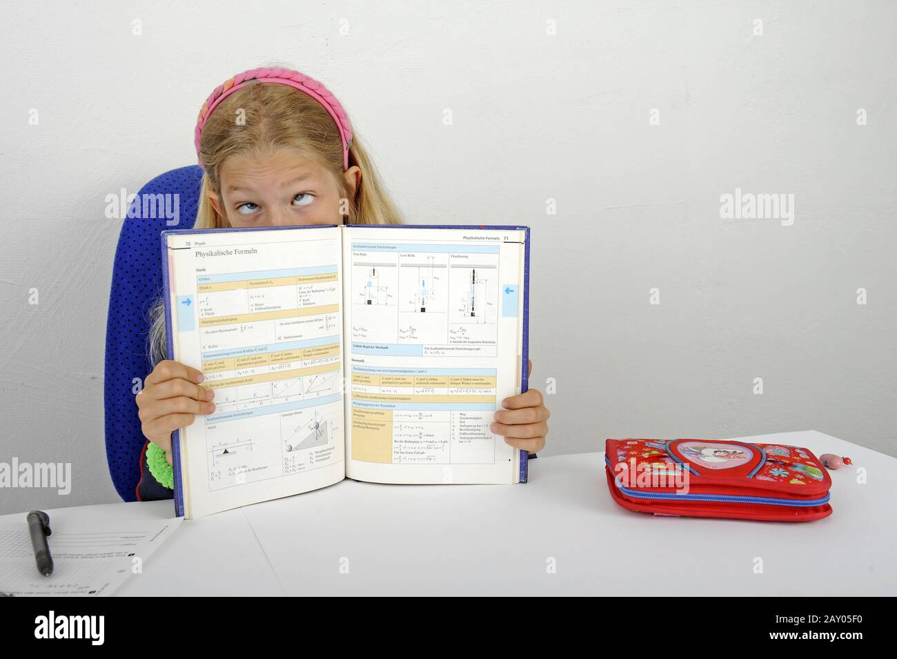 young student shows difficult formulas in a textbook and therefore rolls her eyes Stock Photo