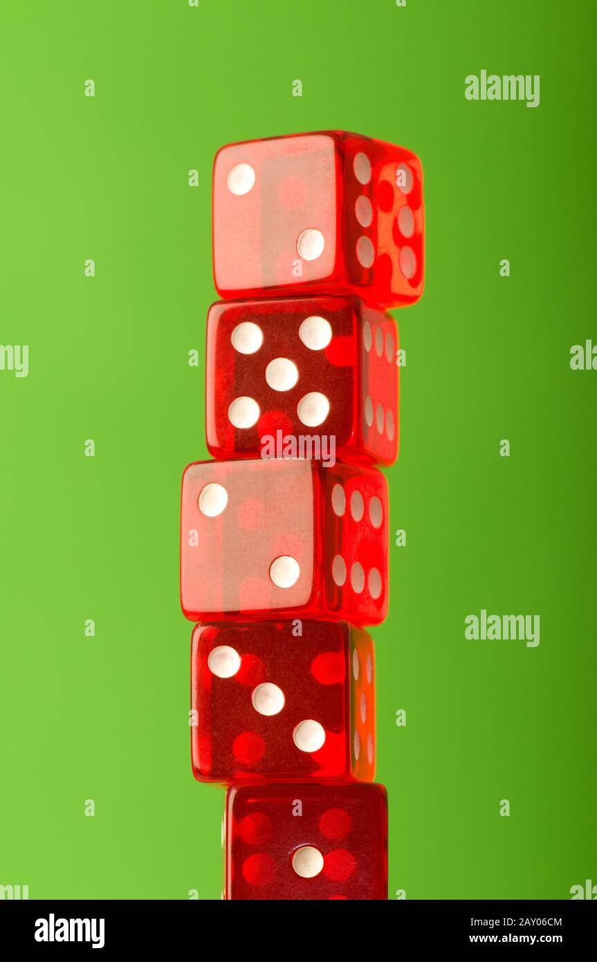 Red dice stack against blurred green background Stock Photo Alamy