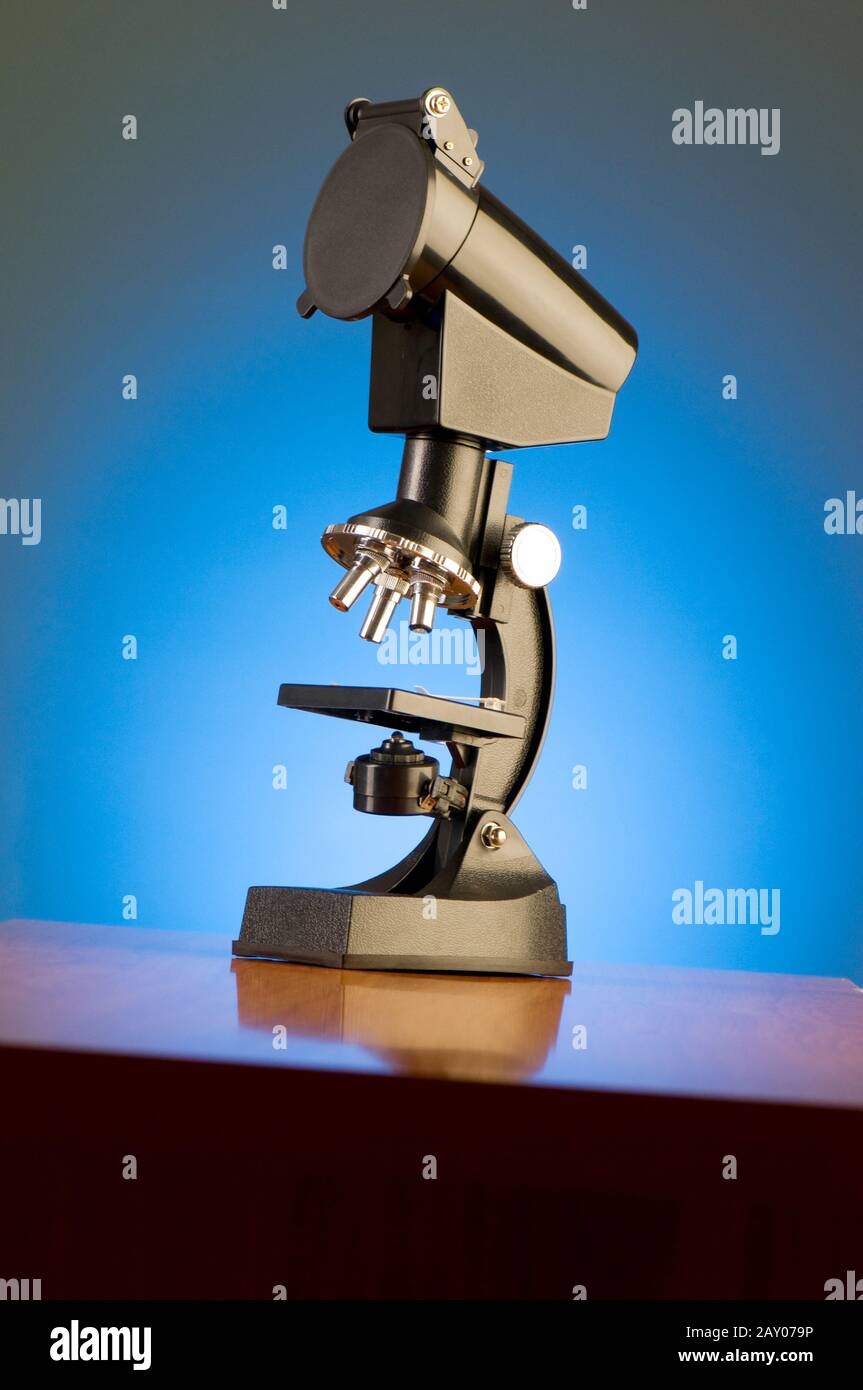 Microscope against blue gradient background Stock Photo - Alamy