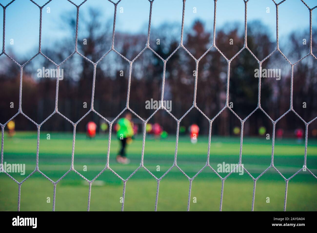 Football match behind soccer net, sport photo Stock Photo Alamy