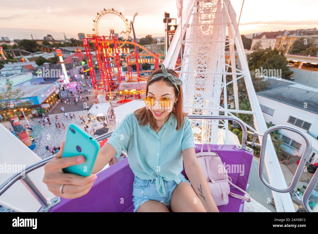Happy asian woman smiling and taking selfie photo on a ferris wheel Stock Photo