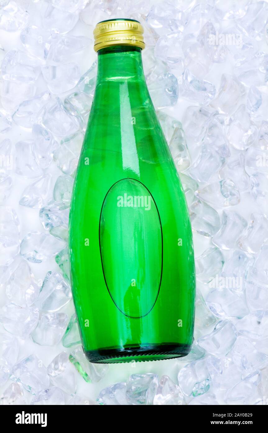 Green bottle of water on ice cubes Stock Photo - Alamy