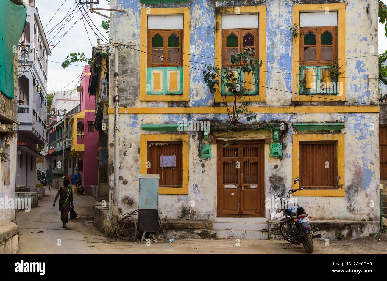 Diu, India - December 2018: An old, faded house with colorfully painted rectangular windows on the streets of the island of Diu. Stock Photo