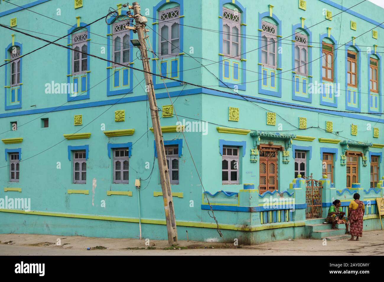 Diu, India - December 2018: An old,  bright turquoise green house with old-fashioned, colorful windows in the streets of the island town of Diu. Stock Photo