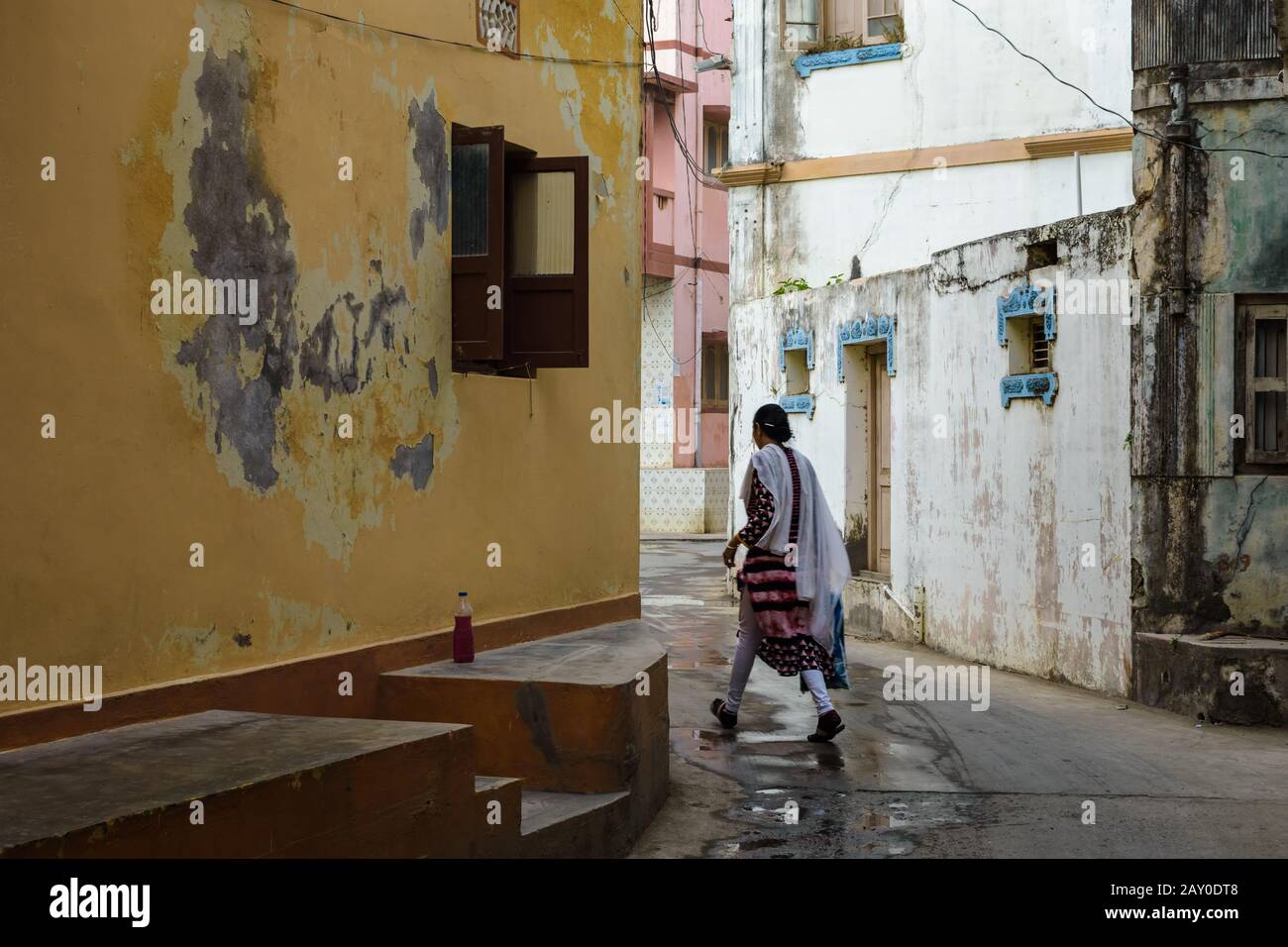 Diu, India - December 2018: A woman walks in the quiet, narrow streets of the town of Diu. Stock Photo