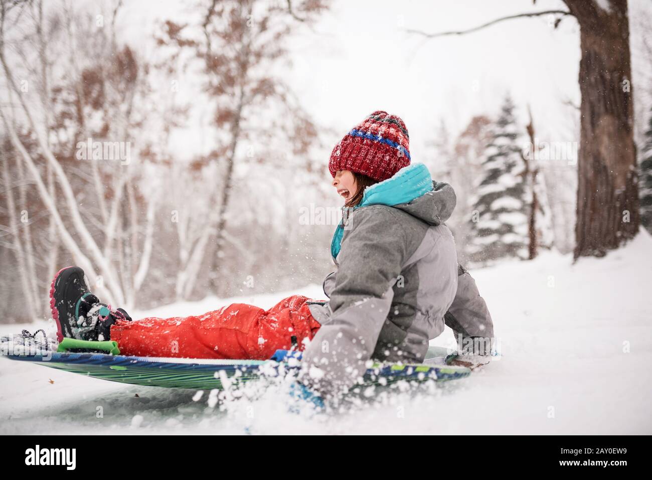 Happy girl sledging in the snow, Wisconsin, USA Stock Photo