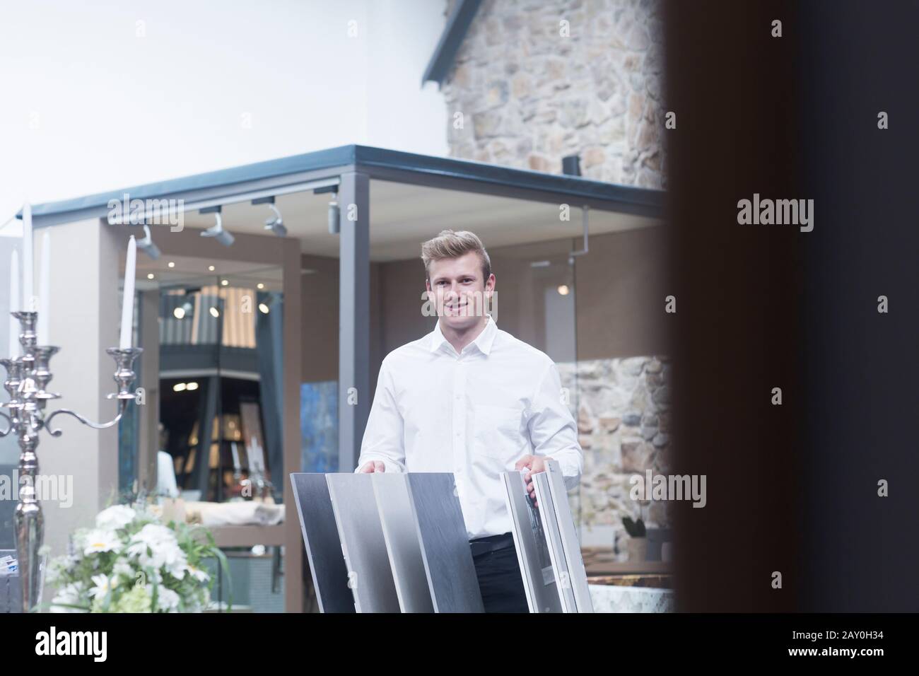 Salesman standing in a shop next to flooring samples, Germany Stock Photo