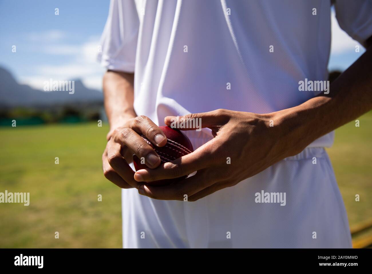 Cricket player standing and holding a ball Stock Photo