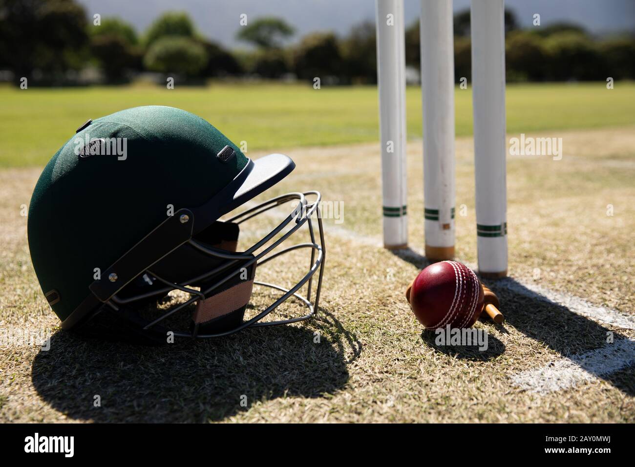 Cricket ball and helmet on a pitch Stock Photo
