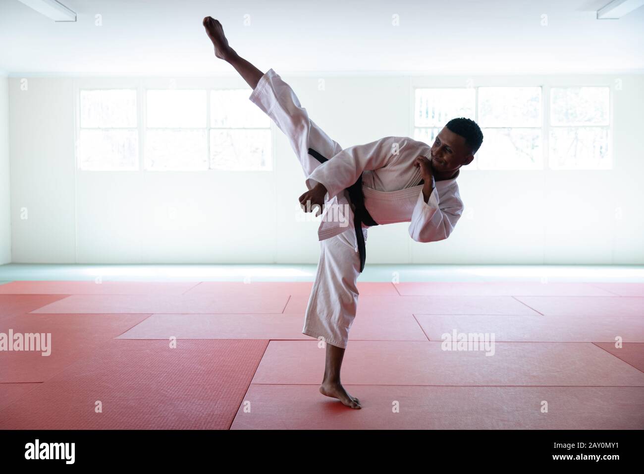 Karate stretching his leg up and kicking the air Stock Photo - Alamy