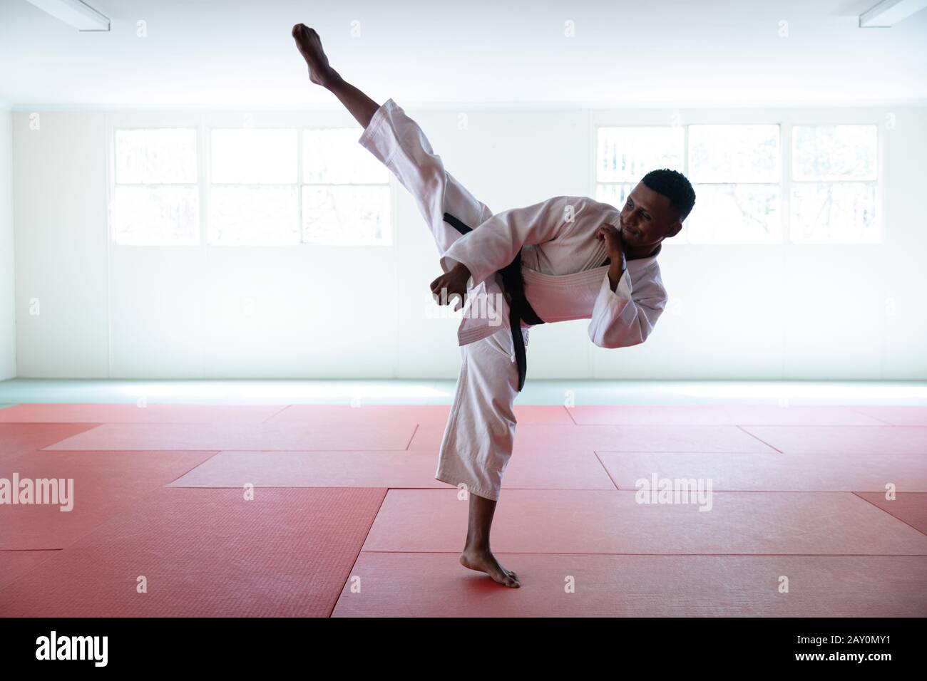 Karate stretching his leg up and kicking the air Stock Photo