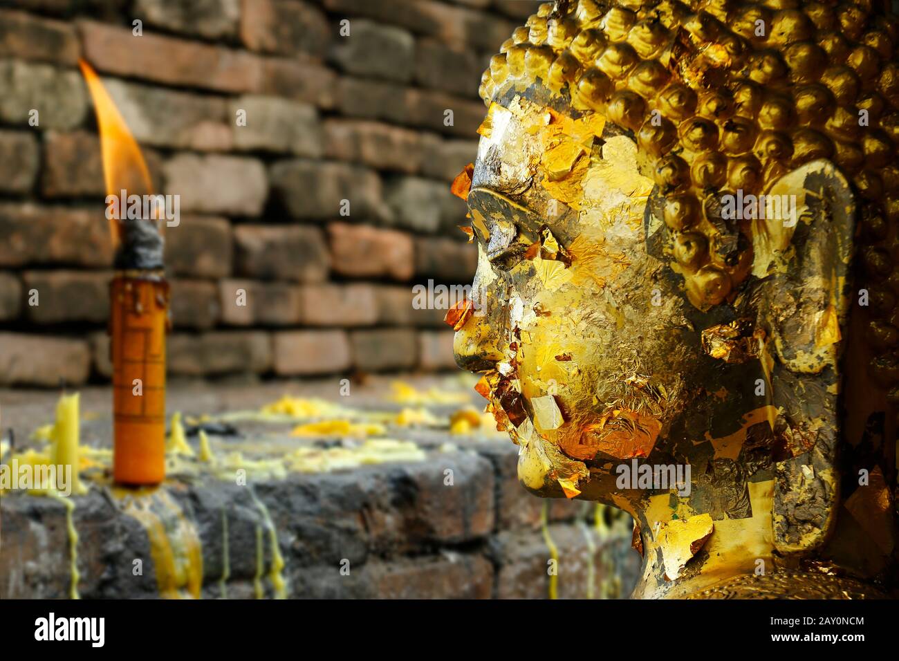 Head of statue of buddha, with buddhist candle Stock Photo Alamy