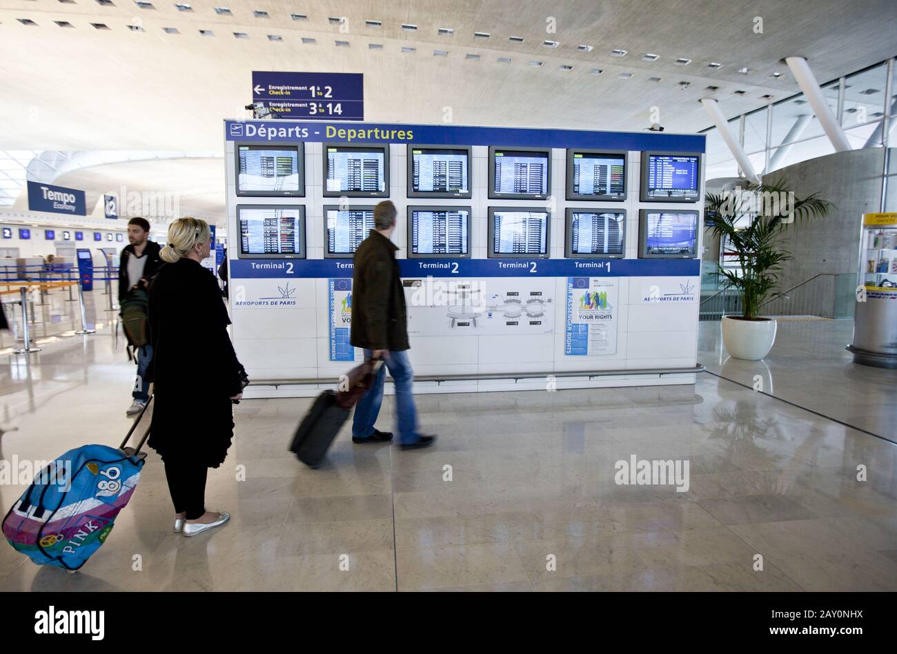 A woman is standing in front of departure information in the departure hall of Terminal 2 Stock Photo