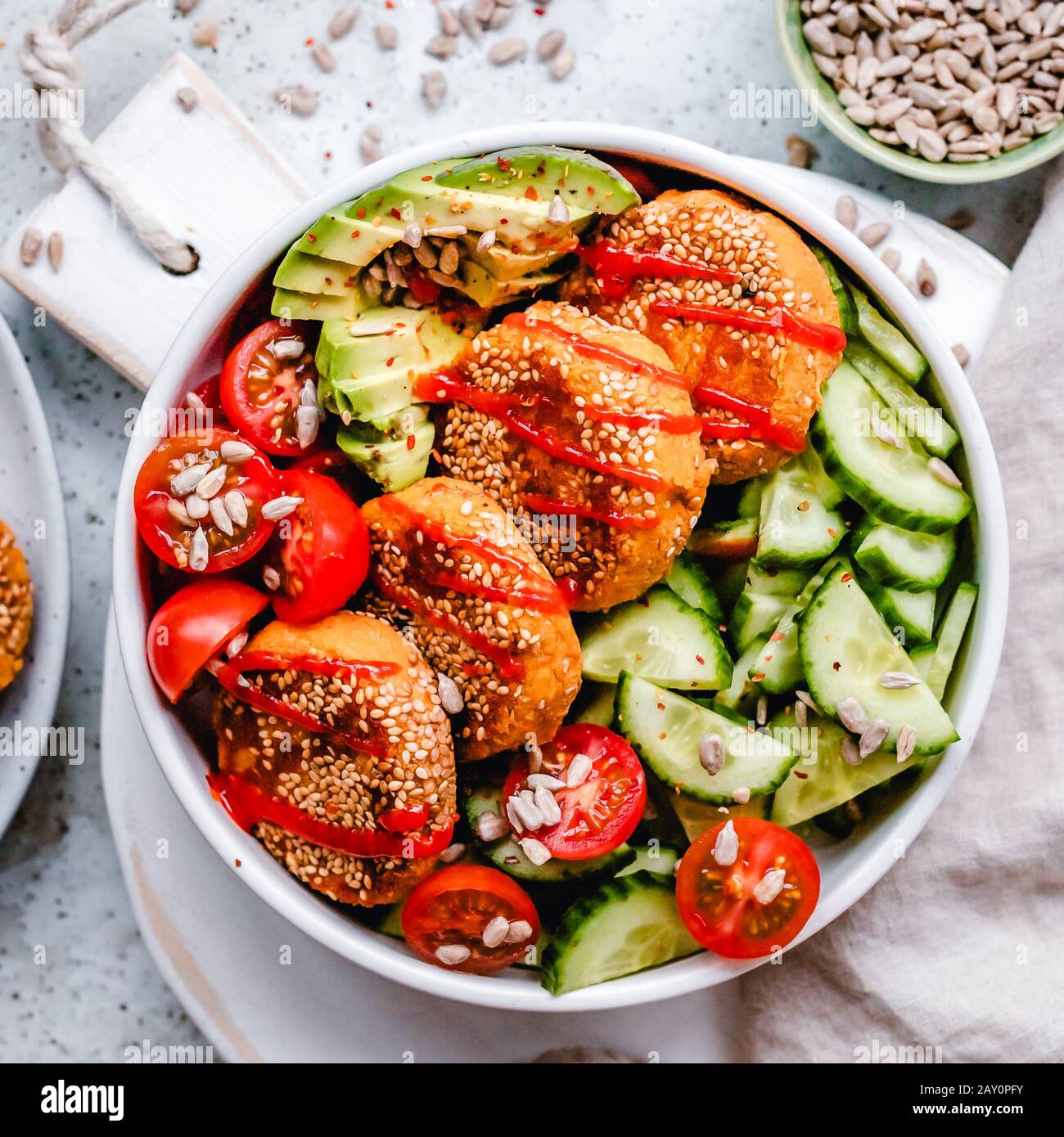 Sweet potato falafel bowl with tomato, cucumber, avocado and sunflower seeds Stock Photo