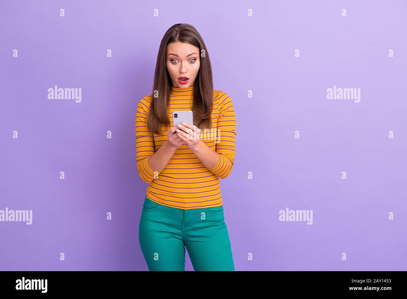 Portrait of crazy astonished girl social network user use smart phone read comment feedback impressed scream wow omg wear good look jumper trousers Stock Photo