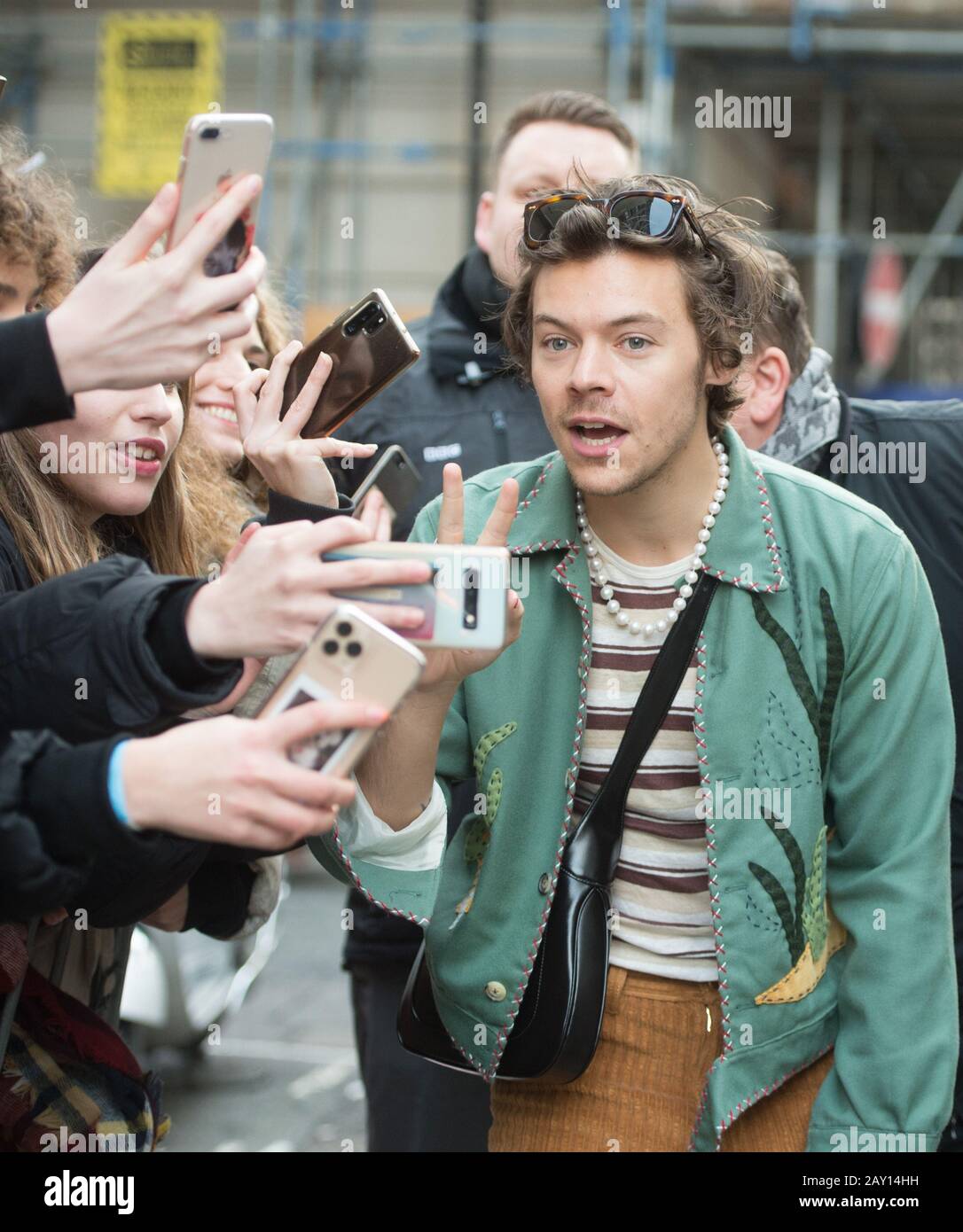 Harry Styles takes a selfie with a fan as he leaves the BBC Radio studios  in Wogan House, London, after an appearance on Radio 2's The Zoe Ball  Breakfast Show Stock Photo -