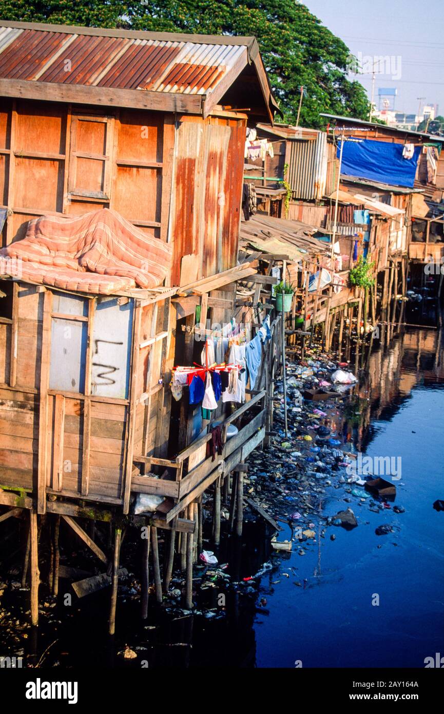 Riverside slum homes made up of shacks along a canal strewn with rubbish in Jakarta, Indonesia, June 1995 Stock Photo