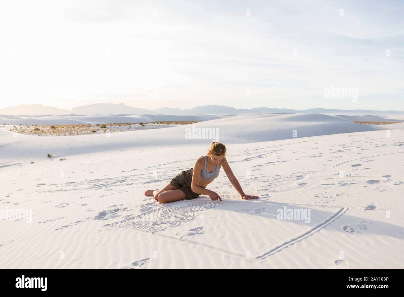 13 year old girl drawing in the sand, White Sands Nat'l Monument, NM Stock Photo