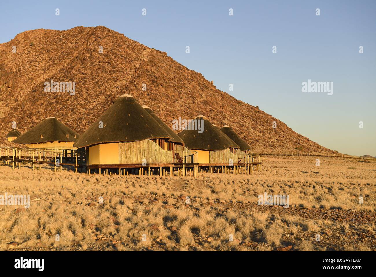 Huts, chalets of Sossus Dune Lodge in the evening light, Namib Nauk Stock Photo