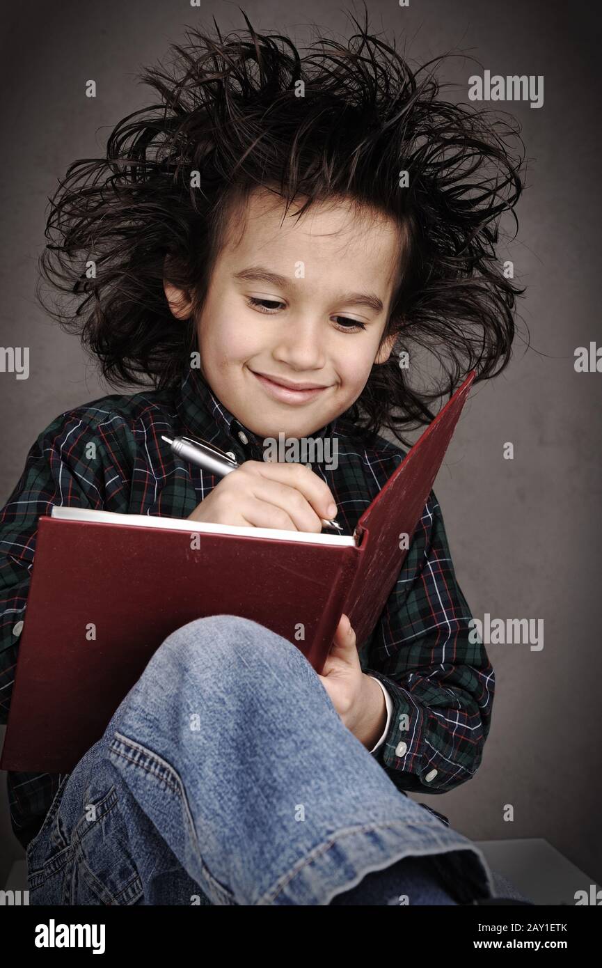 Smart nerd kid with glasses and funny hair writing Stock Photo Alamy