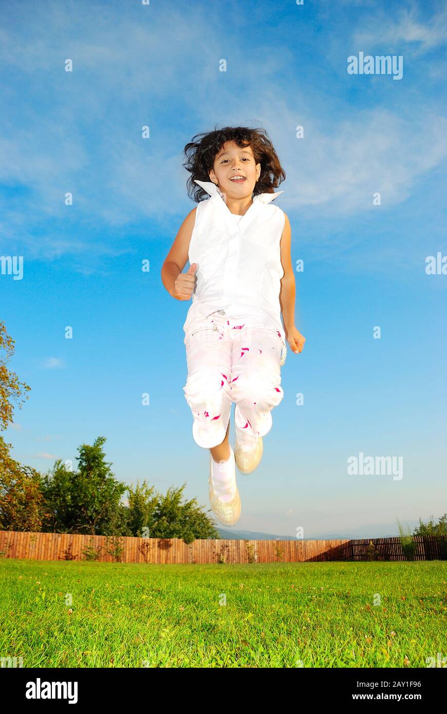 Little girl jumping against beautiful sky Stock Photo - Alamy