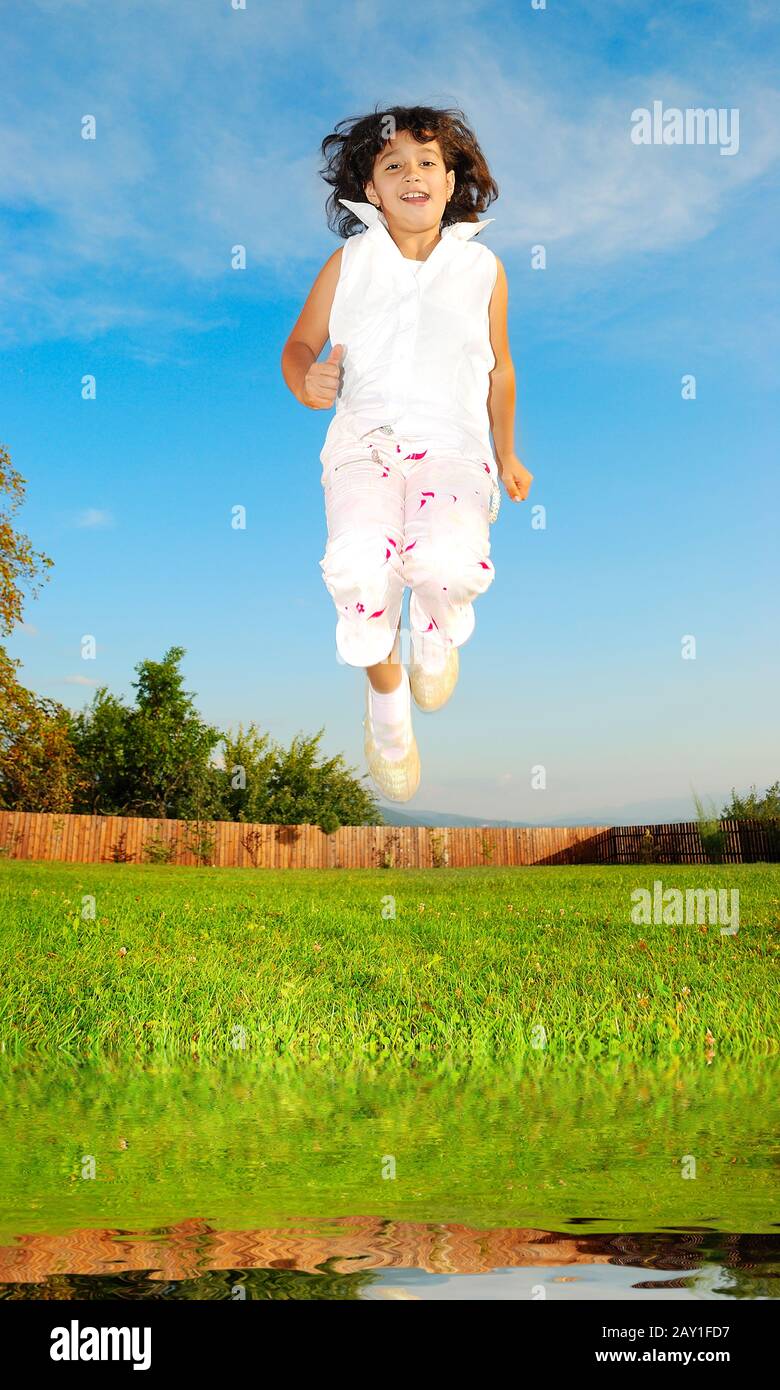 Little girl jumping against beautiful sky Stock Photo - Alamy