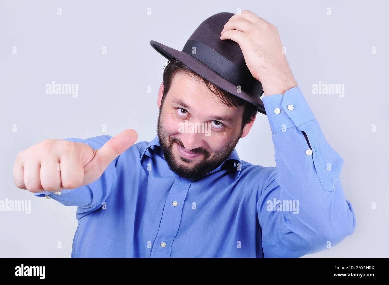 Young man with hat and pointing with his thumb up Stock Photo