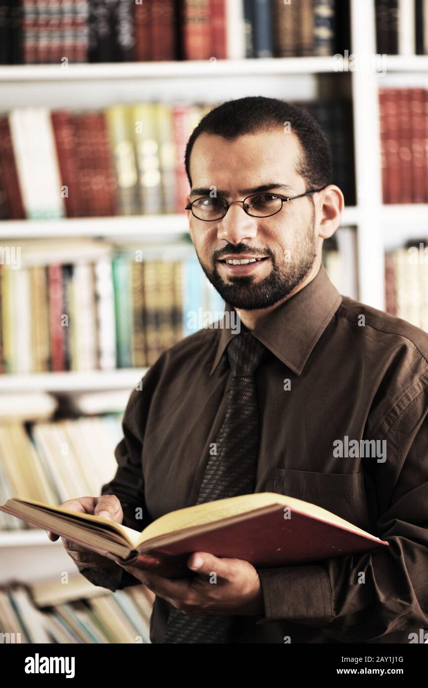 Young man reading book in library Stock Photo