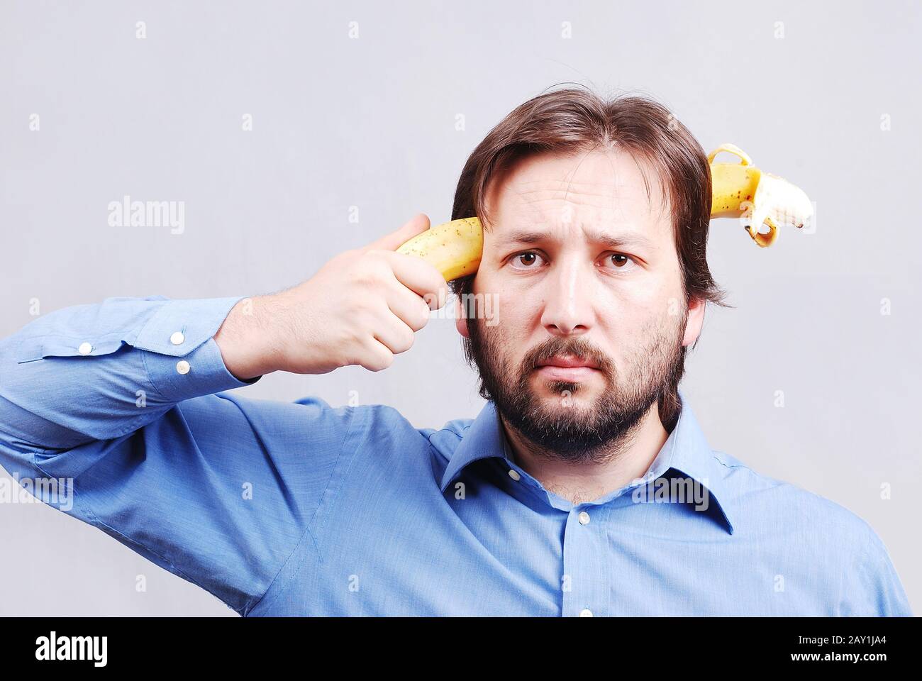Young man blowing up his brain with banana Stock Photo Alamy